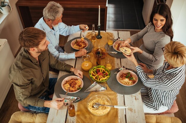 Zwei-Generationen-Familie beim gemeinsamen Mittagessen zu Hause