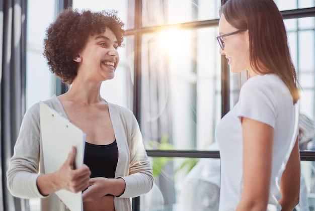 Foto zwei geschäftsfrauen, die hände im modernen büro rütteln