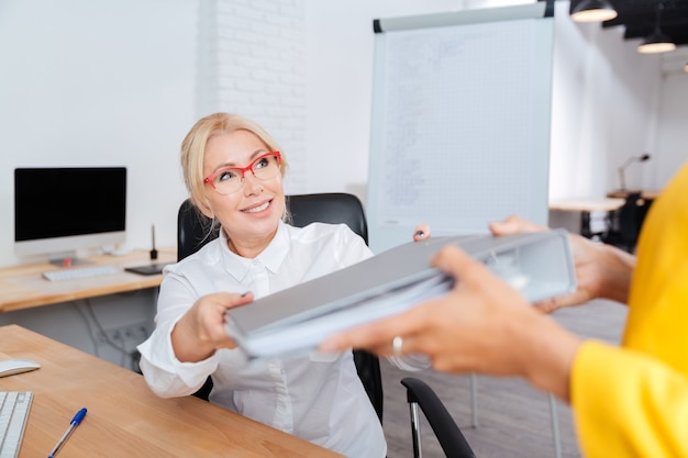 Zwei Geschäftsfrauen, die im Büro mit Ordnern arbeiten