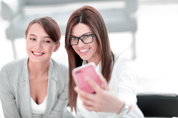 Zwei Geschäftsfrauen machen Selfies im Büro