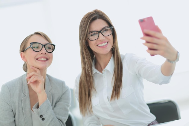 Zwei Geschäftsfrauen machen Selfies im Büro