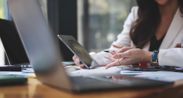 Zwei Geschäftsfrauen treffen sich, um die Situation auf dem Markt mit einem digitalen Tablet im Büro zu besprechen