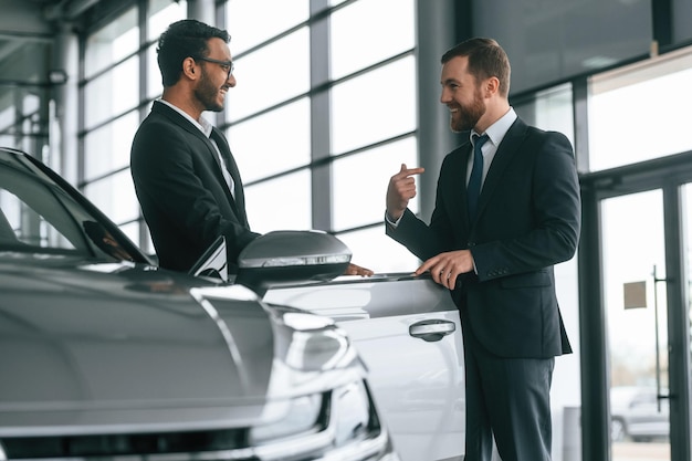 Zwei Geschäftsleute arbeiten zusammen im Auto-Showroom