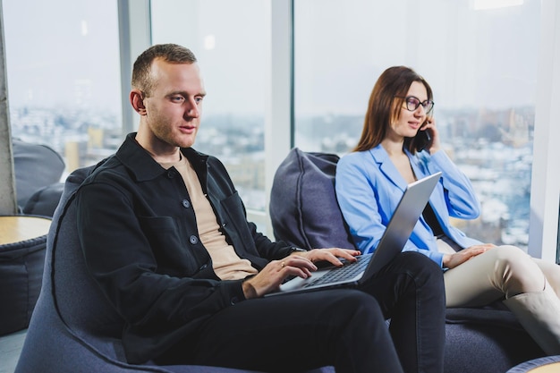 Zwei Geschäftsleute, die mit einem Laptop remote online arbeiten Kollegen arbeiten remote im Arbeitsbereich