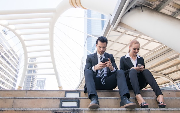 Zwei Geschäftsleute, die Smartphones verwenden