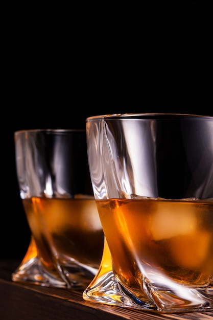 Zwei Gläser Alkohol an einer Holzwand