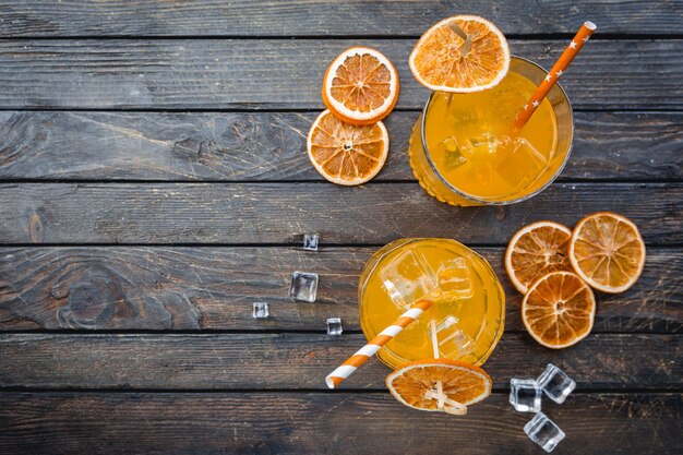 Zwei Gläser Aperol-Soda-Cocktail mit Eiswürfeln über Dunkelheit