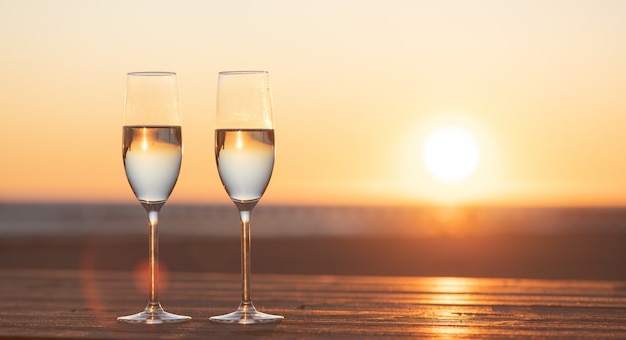 zwei Gläser Champagner auf dem Tisch bei Sonnenuntergang