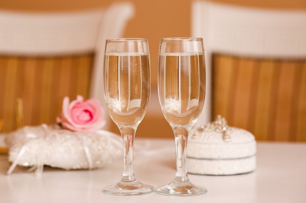 Zwei Gläser Champagner auf einem Hochzeitstisch im klassischen Stil.