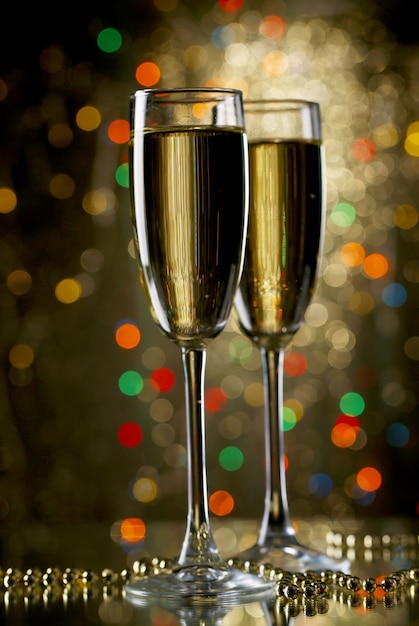 Zwei Gläser Champagner auf hellem Hintergrund mit Lichtern