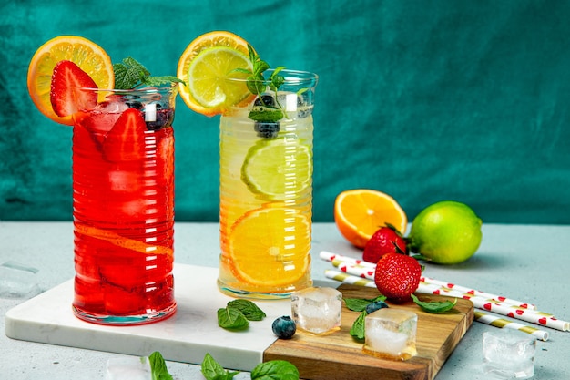 Zwei Gläser erfrischende Sommerlimonade mit Eis. Cocktail mit Erdbeere und Zitrone und Cocktail mit Zitrone und Limette