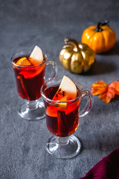 Zwei Gläser Glühwein zu Weihnachten mit Orangen und Gewürzen.