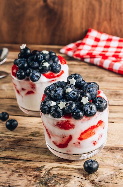 Zwei Gläser Joghurt mit Beeren amerikanisches patriotisches Frühstück selektiver Fokus