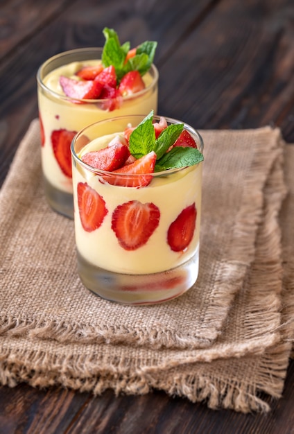 Zwei Gläser Mangopudding mit frischen Erdbeeren garniert mit frischer Minze