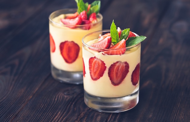 Zwei Gläser Mangopudding mit frischen Erdbeeren garniert mit frischer Minze