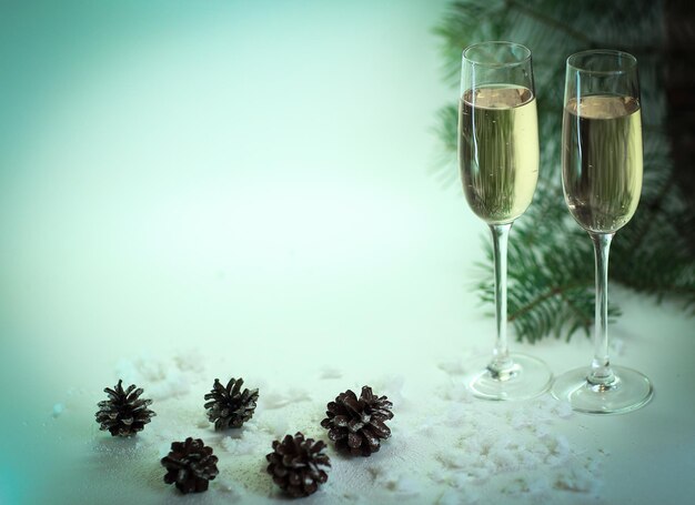 Zwei Gläser mit Champagner und Zapfen auf dem Weihnachtshintergrund