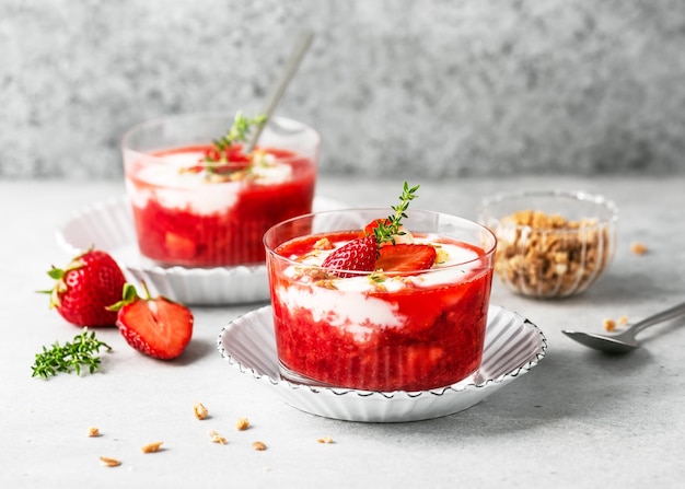 Zwei Gläser mit kaltem Sommerdessert Erdbeersauce und Joghurtcreme