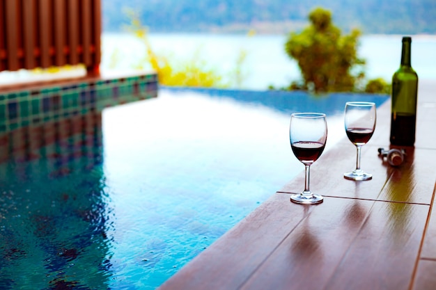 Zwei Gläser Rotwein in der Nähe des Swimmingpools mit einem spektakulären Blick auf das Meer