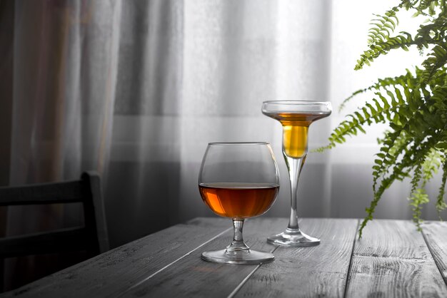 Zwei Gläser Wein gesetzt auf einen Holztisch auf dem Hintergrund eines Fensters