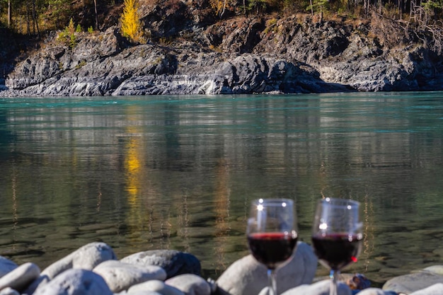 Zwei Gläser Wein mit Blick auf die Berge des Flusses Katun in Gorny Altai Rotwein in zwei Gläsern