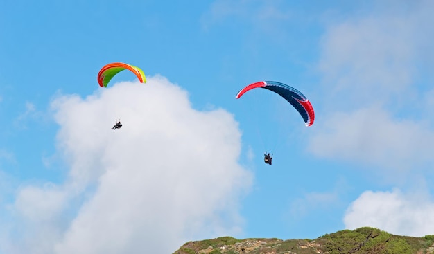 Zwei Gleitschirme fliegen an einem bewölkten Tag