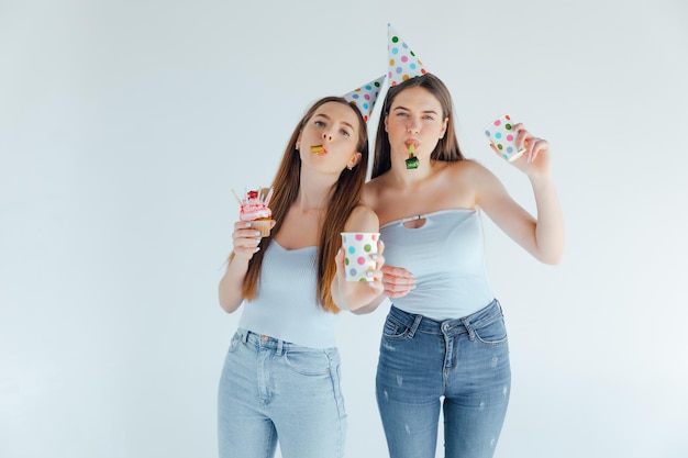 Zwei glückliche Freunde feiern Geburtstag in Partyhüten