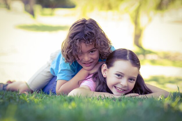 Zwei glückliche junge Kinder, die am Park spielen
