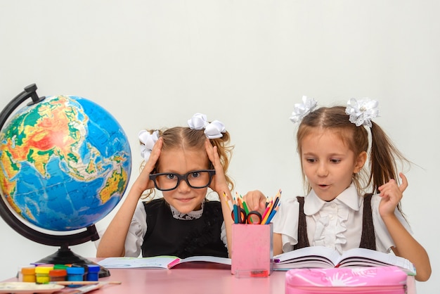 zwei glückliche kleine Mädchen lernen und schreiben in der Klasse isolieren