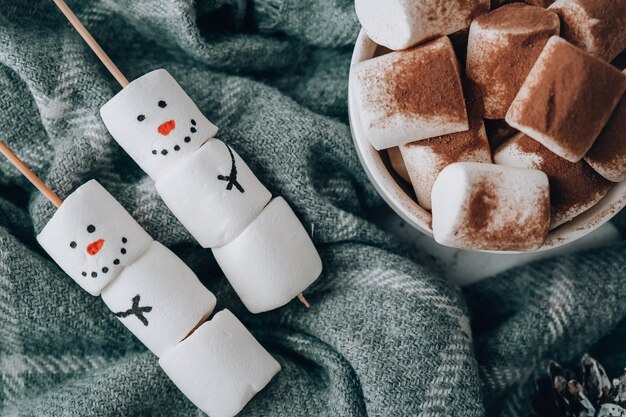 Zwei glückliche lustige Eibisch-Schneemänner. Marshmallow-Freunde. Heimwerken. Süße Leckerei für Kinder lustiger Eibisch-Schneemann. Weihnachtsdekoration für den Winterurlaub. Tasse Kakao