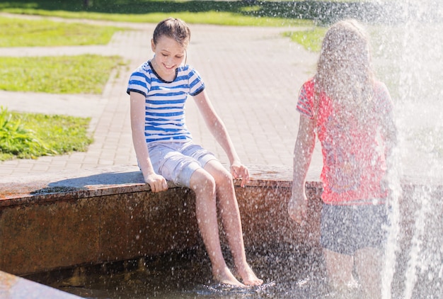 Zwei glückliche Mädchen am Brunnen