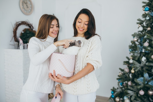 Zwei glückliche Mädchen öffnen Weihnachtsgeschenke.