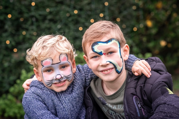 Zwei glückliche süße kleine Jungs mit bemalten Gesichtern