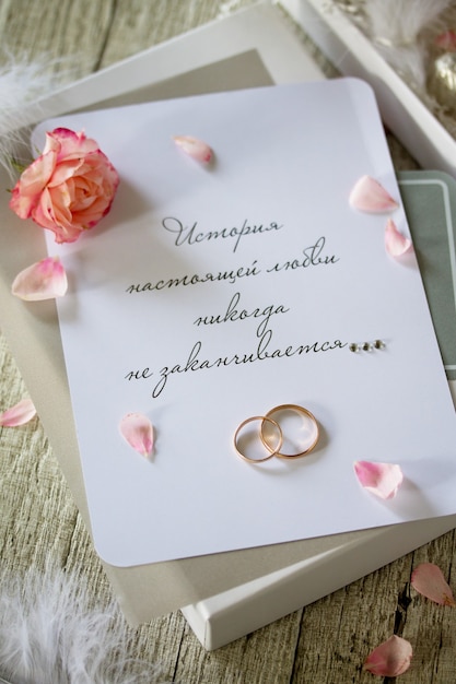 Foto zwei goldene eheringe pralinenschachtel und eine hochzeitseinladung