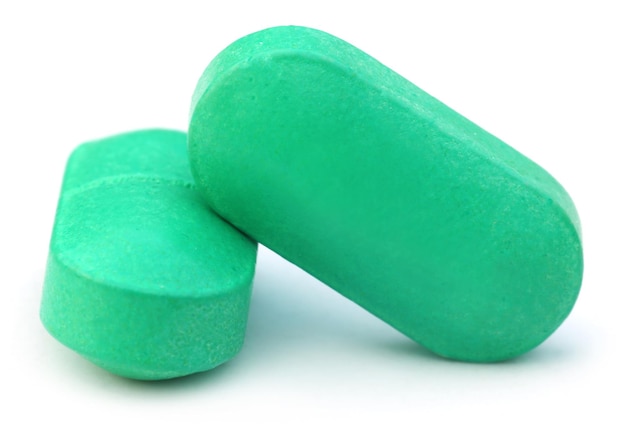 Zwei grüne Tabletten auf weißem Hintergrund