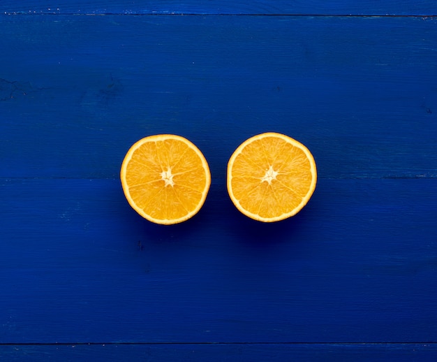 Foto zwei hälften einer orange runden orange auf einem dunkelblauen hintergrund von den brettern gemalt in der blauen tendenzfarbe