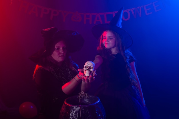 Foto zwei halloween-hexen, die einen trank machen und in halloween-nacht-magie-feiertagen und mystikern beschwören