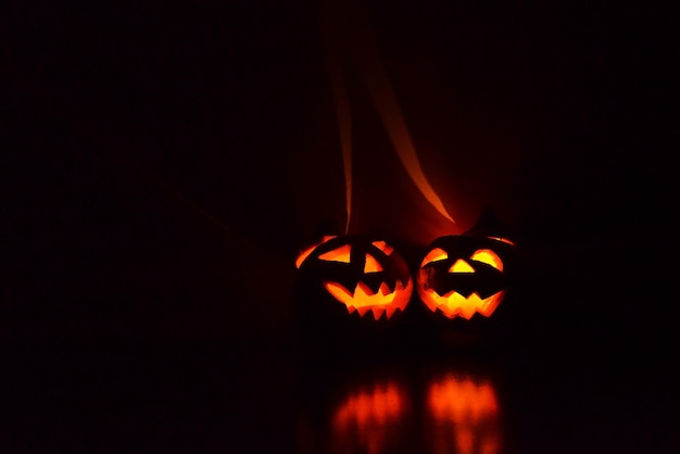 zwei Halloween-Kürbisse leuchten im Dunkeln