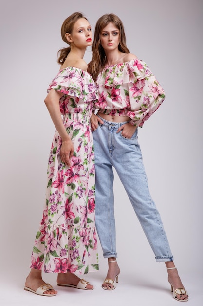 Zwei High Fashion Models im langen Kleid mit einer roten Bluse mit Blumenmuster blaue Jeans Schöne Frauen