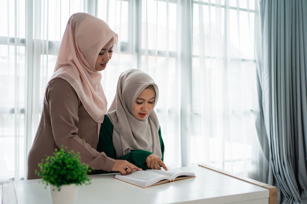 Zwei Hijab-Frauen studieren und lesen das heilige Buch Al-Quran