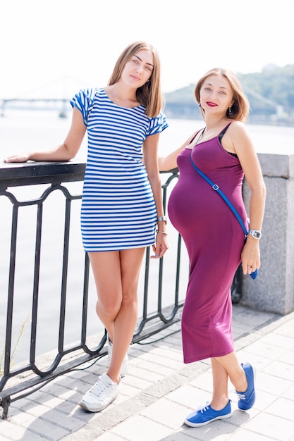 Zwei hübsche Frauen, die auf Stadtdamm gehen