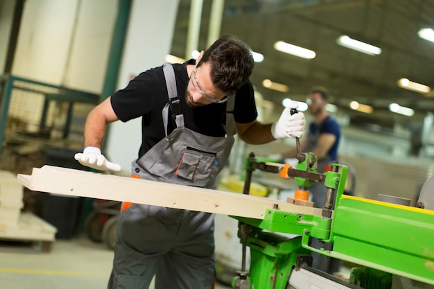 Zwei hübsche junge Männer, die in der Bauholzwerkstatt arbeiten