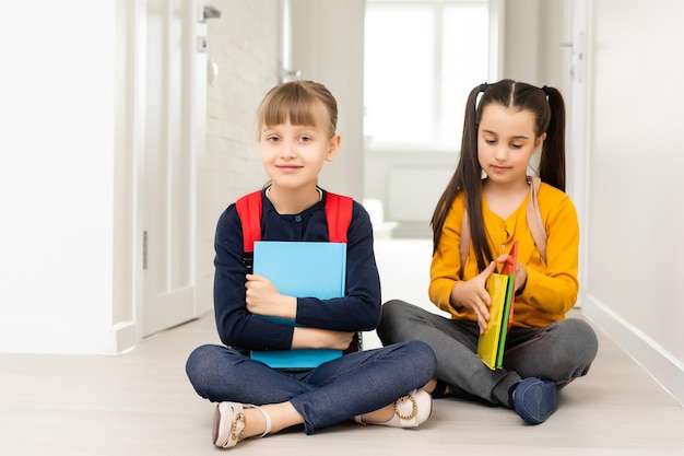 zwei hübsche junge Schulmädchen. Mädchen tragen Notizbücher.