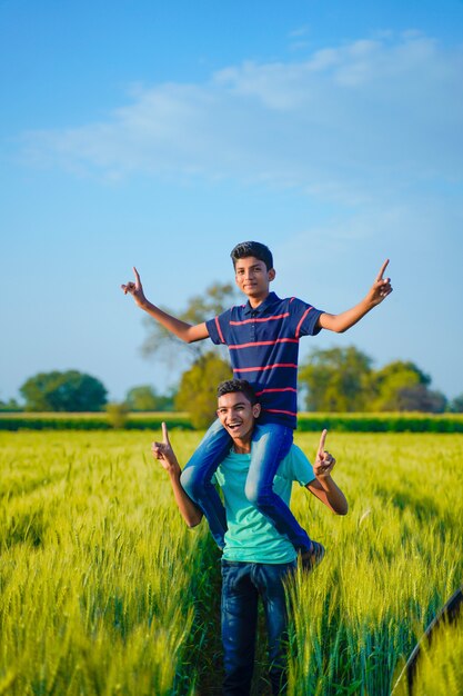 Zwei indische ländliche Bruder spielen auf dem Feld