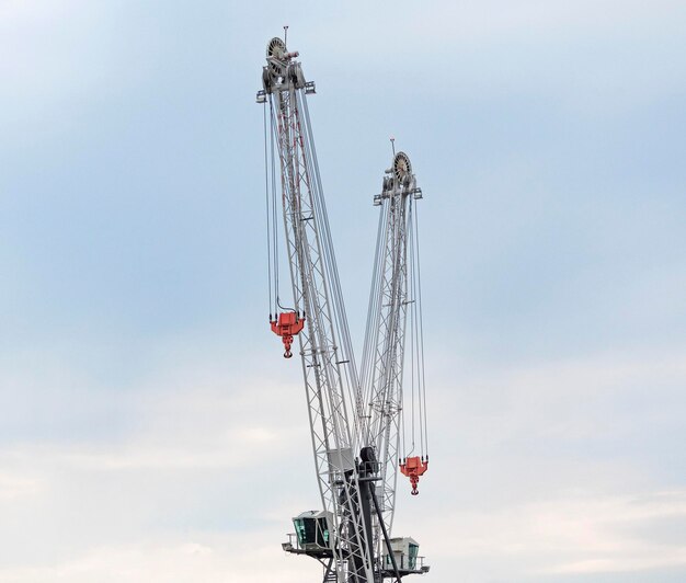 Zwei Industriekräne für Hochbau oder Gewichtheben am Himmelshintergrund