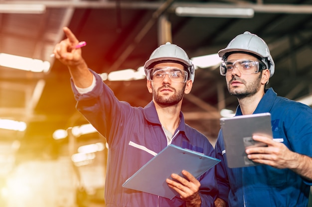 Foto zwei ingenieur arbeiten zusammen mit sicherheitsuniform und weißem helm