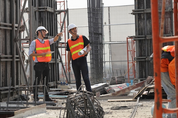 Zwei Ingenieure arbeiten auf der Baustelle. Sie überprüfen den Fortschritt der Arbeit.