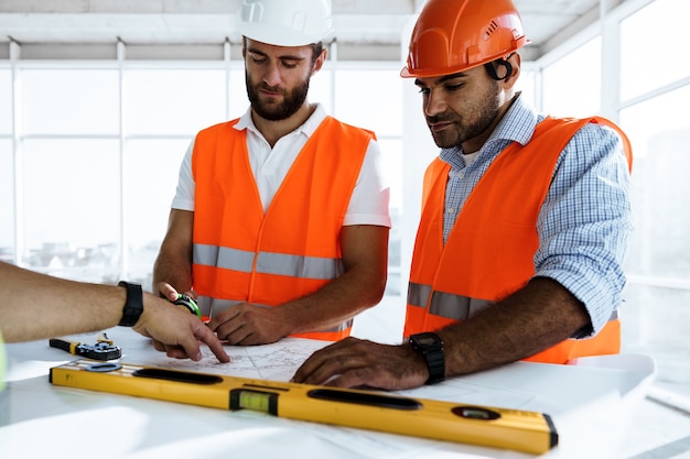Zwei Ingenieure betrachten den Projektplan auf dem Tisch auf der Baustelle
