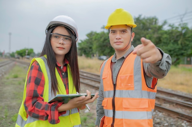 Zwei Ingenieure, die am Bahnhof arbeiten, arbeiten glücklich zusammen, helfen sich gegenseitig, das Problem zu analysieren, beraten sich über Entwicklungsrichtlinien