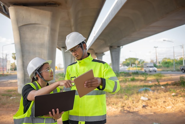 Zwei Ingenieure diskutieren über Arbeiten auf der Baustelle einer großen Brücke im Bau