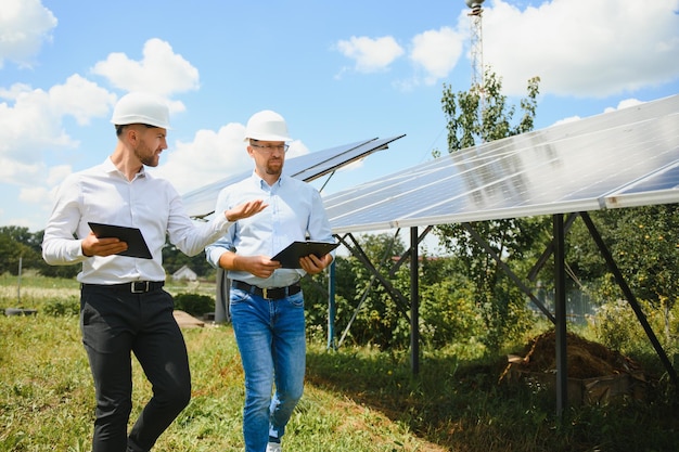 Zwei Ingenieure führen eine Außeninspektion von Photovoltaikmodulen durch